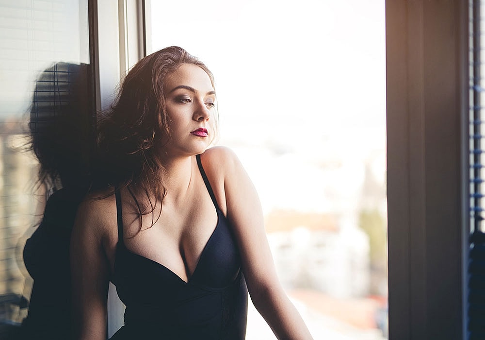 Woman gazing thoughtfully by a window.