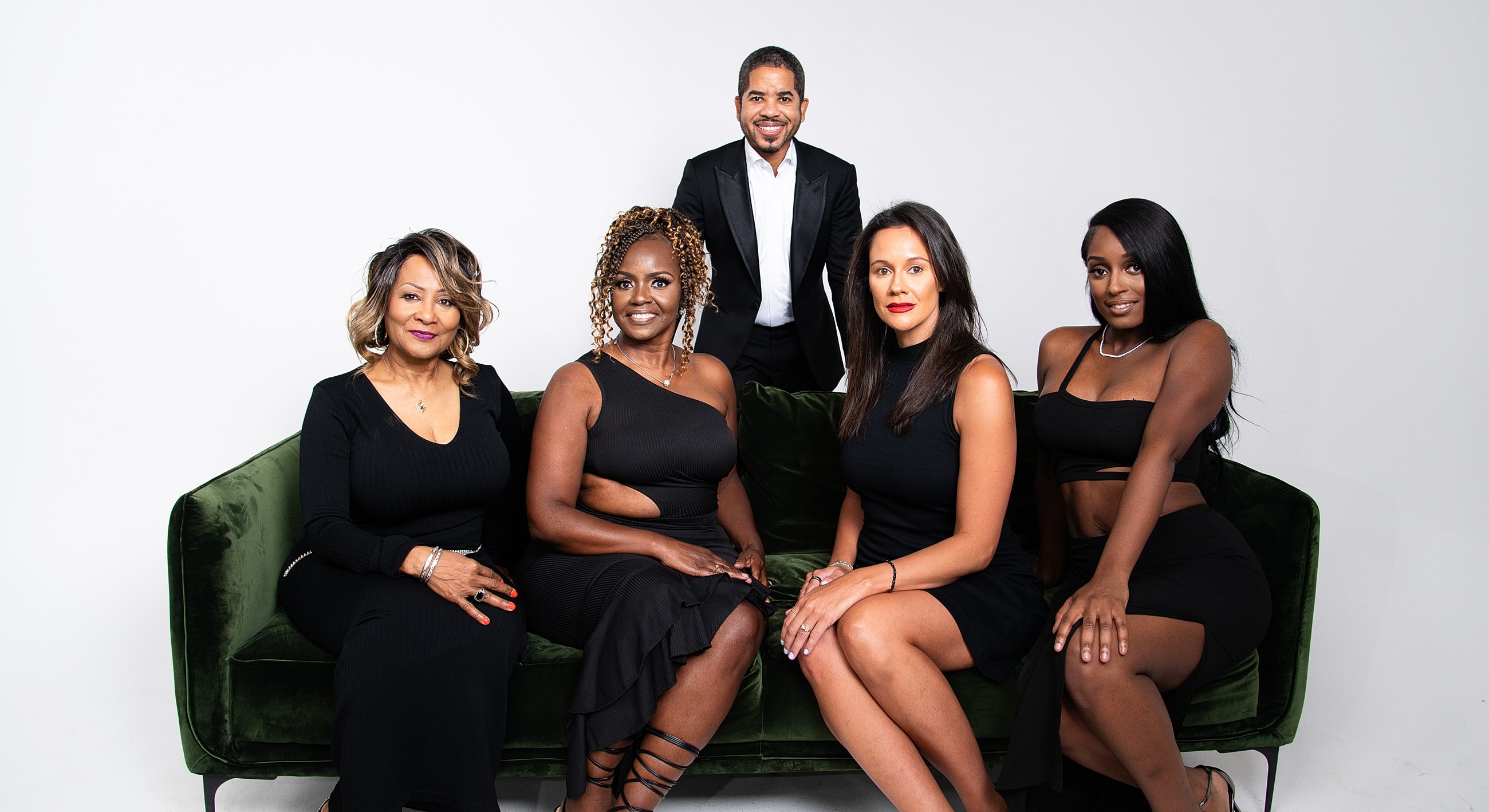 Group portrait of stylish individuals on a couch.