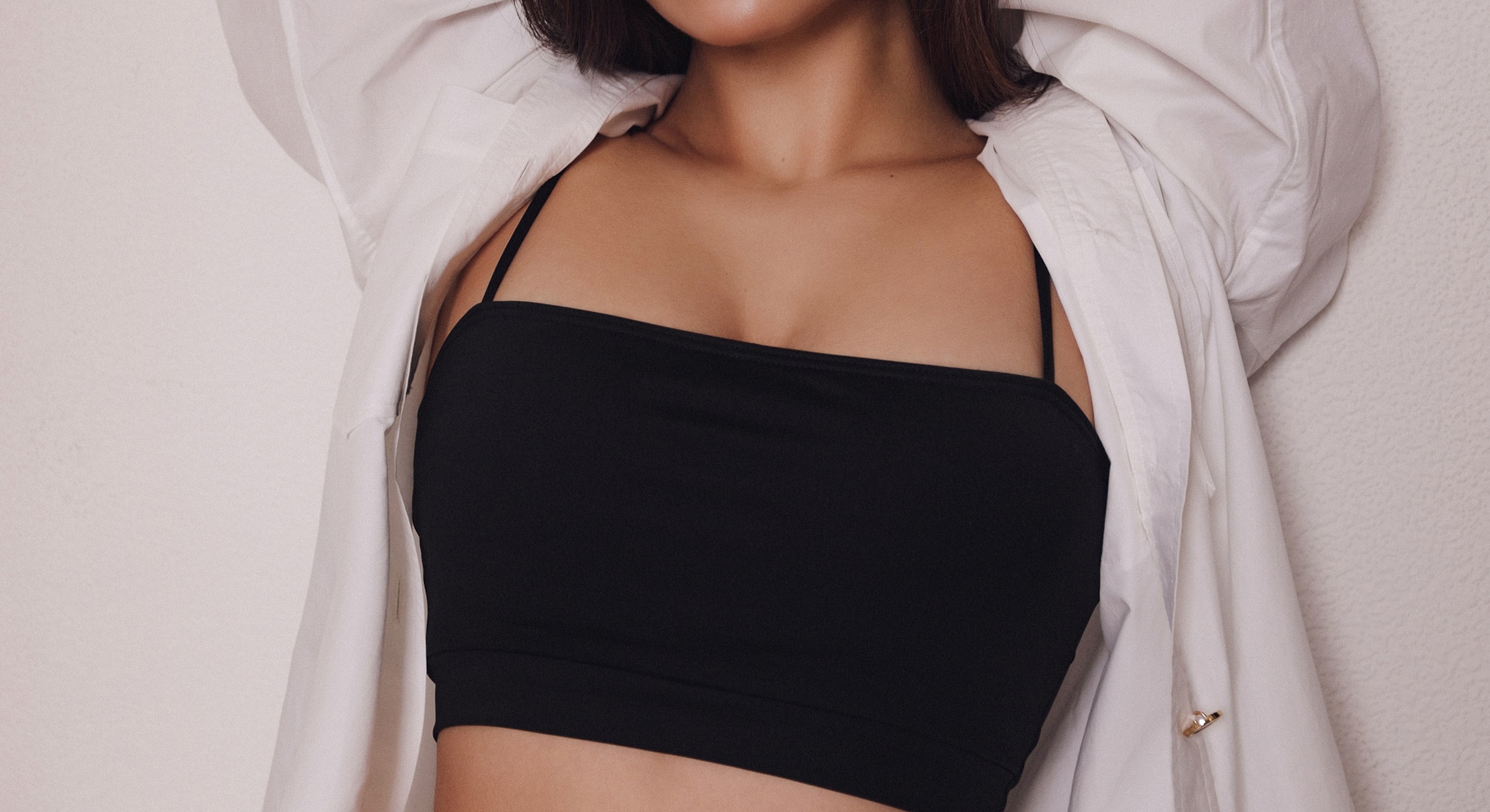 Model in black crop top and white shirt.