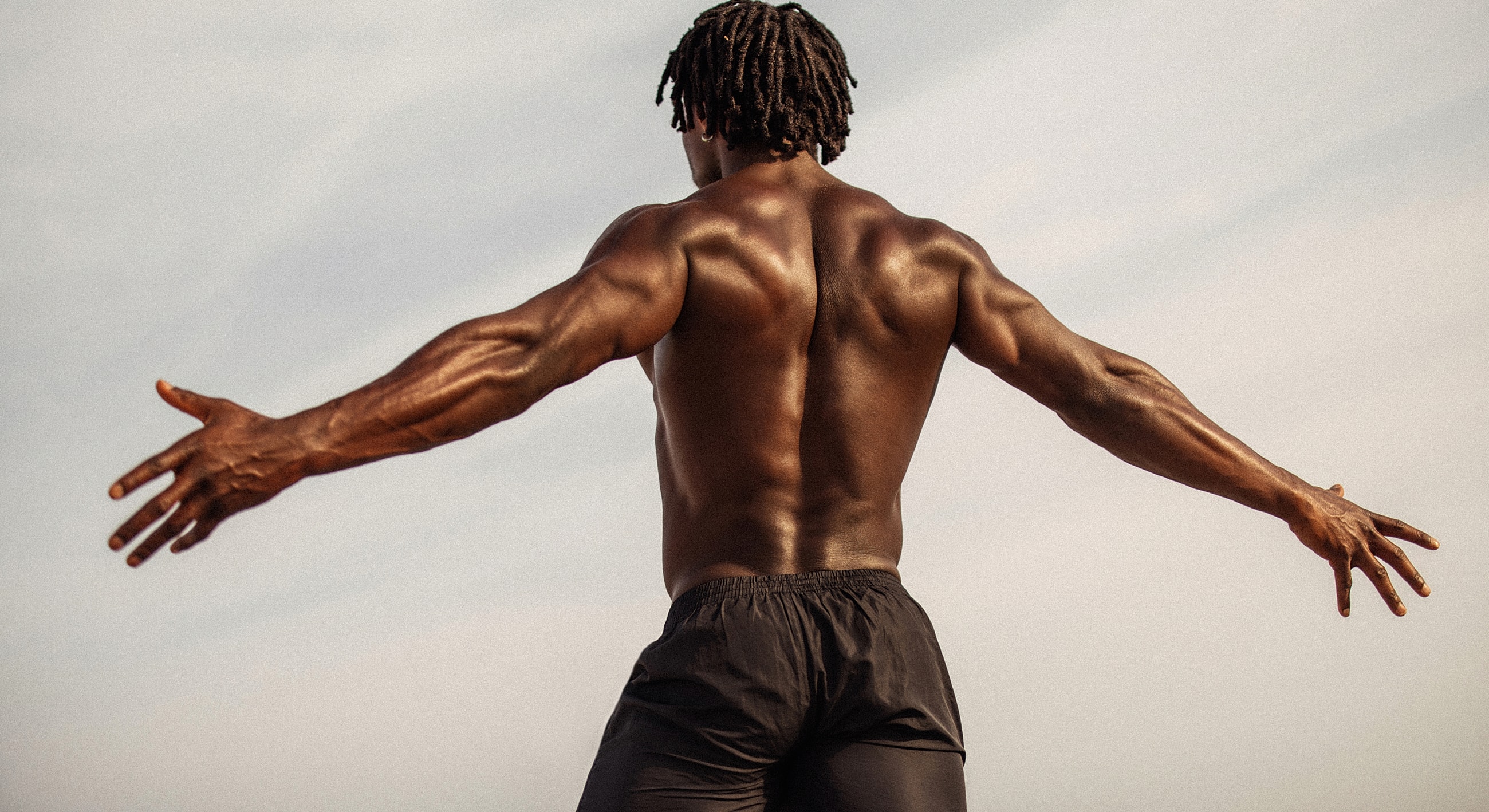 Atlanta male BBL model standing with arms outstretched.